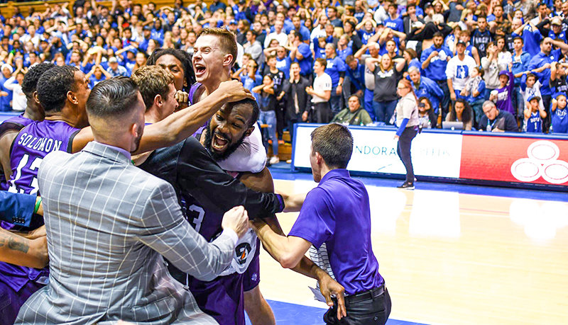 Members of the Stephen F. Austin State University men’s basketball team mob Nate Bain after he hit a game-winning layup to stun the Duke University faithful on Nov. 26. SFA was the first out-of-conference team to beat Duke at Cameron Indoor Stadium in nearly 20 years.