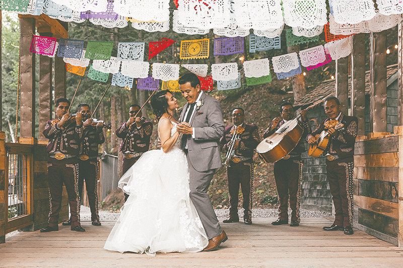 The newlyweds dance to a mariachi band.