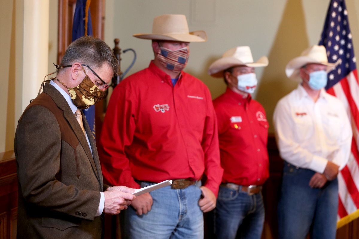 Wyoming Gov. Mark Gordon looks at his notes while standing in front of several rodeo leaders during a Wednesday press conference inside the Capitol in downtown Cheyenne. Joined by rodeo leaders from across the state, Gordon announced the cancellation of the six largest rodeos in Wyoming due to COVID-19 concerns.