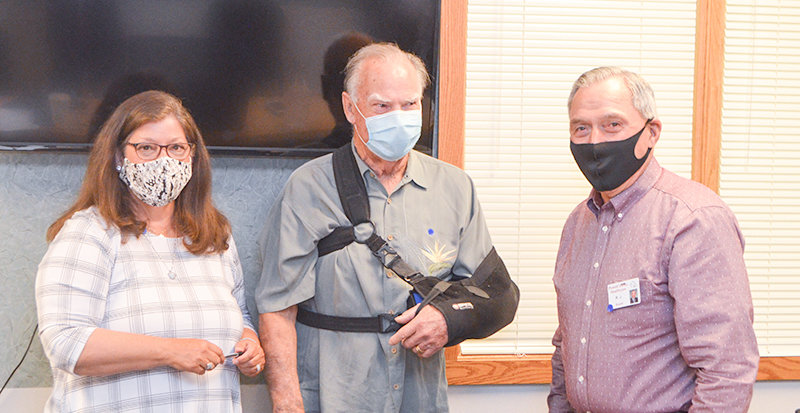 Powell Hospital District trustees Deb Kleinfeldt (left) and R.J. Kost (at right) present Larry Parker with gifts and recognition on Monday, after he announced his retirement from the hospital board following 10 years of service.