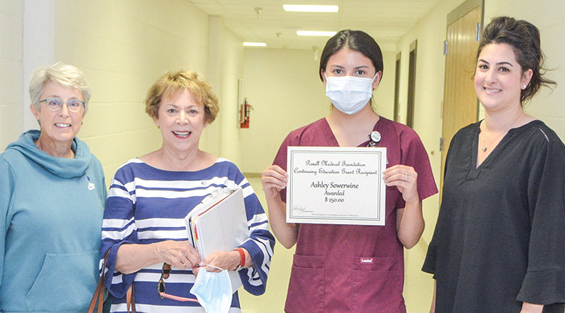Ashley Sowerwine holds up an award certificate she received from the Powell Medical Foundation, alongside board members Caroline Kost, Cindy Blevins and Trish Moulton.