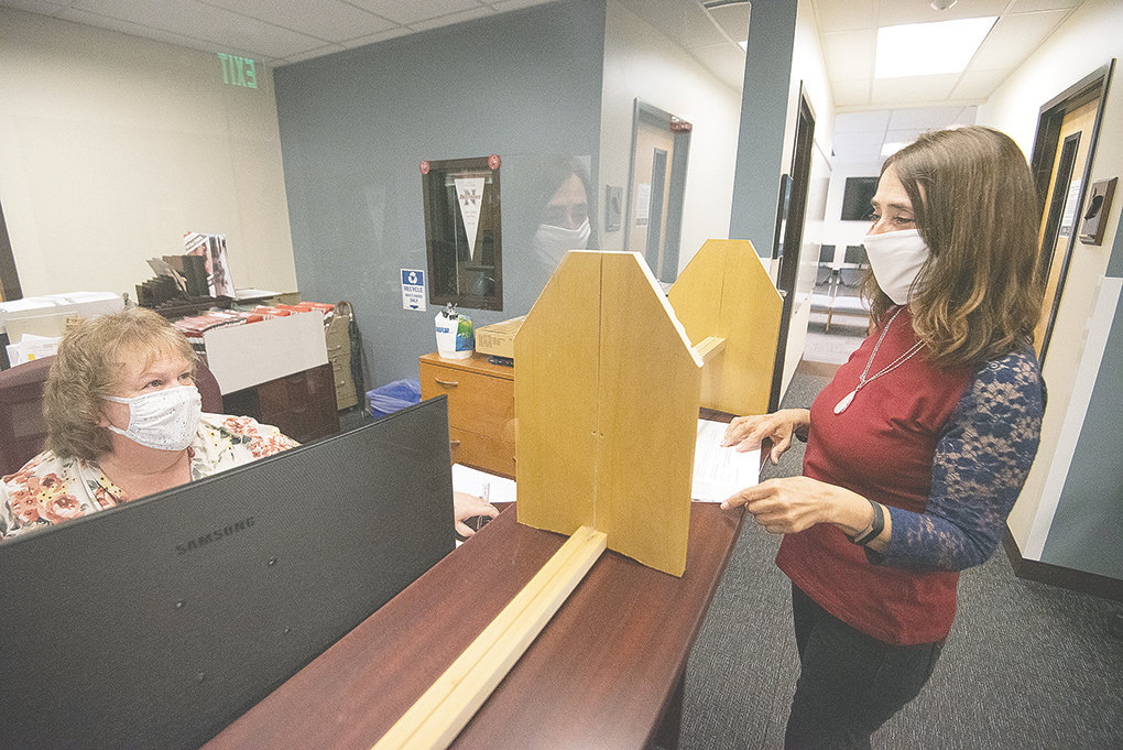 Charlene Kline (left) and Carle Williams work together in the NWC admissions office on Wednesday afternoon. The college adopted a plan this week for fall, which will require all students, faculty and staff to wear masks in most situations on campus.