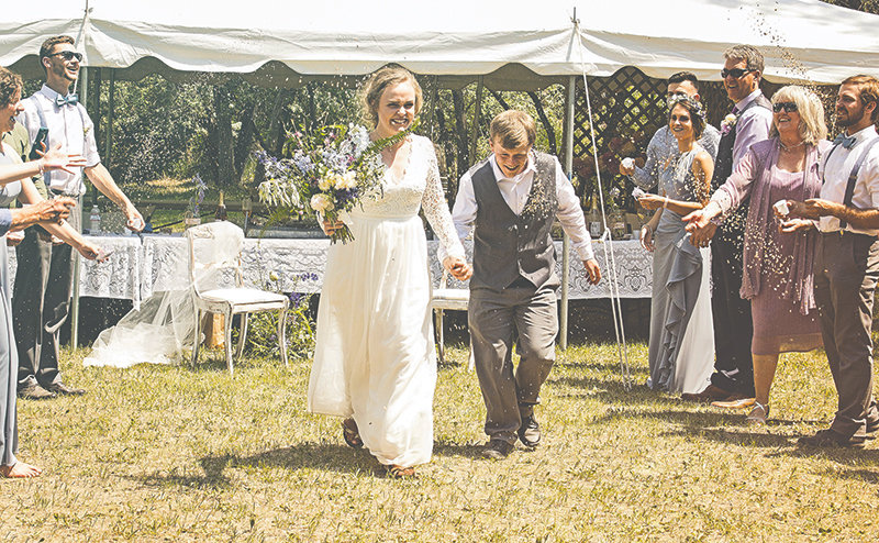 At ceremony’s end, newlyweds Amanda and Colin Harnish are showered with bird seed by Rachel Wurzel and Sumner Ellis, at left; and Kyle Struna, Anya Tracy, Mike Tracy, Karrie Tracy and Seth Robertus, (l-r) at right.