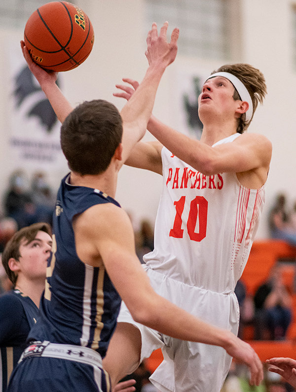 Senior Trevor Groves attempts a layup over Cody’s Luke Talich (2) Saturday against Cody. Coach Mike Heny noted the team’s increased cohesion in the midst of its three-game winning streak.