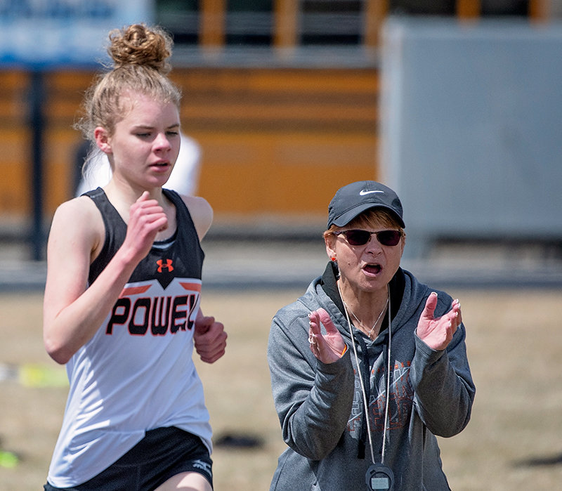 Coach Shelley Heny encourages Brynn Hillman as she competes in a long-distance race Saturday. Hillman placed first in the 1600 run, with a time of 5:55.23.