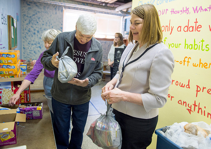 Jennie Gordon gets a hands-on demonstration from Don Rushing at Union Presbyterian Church in Powell while packing food for students in the Backpack Blessings program. Gordon and her staff toured food outreach programs in Powell Thursday.