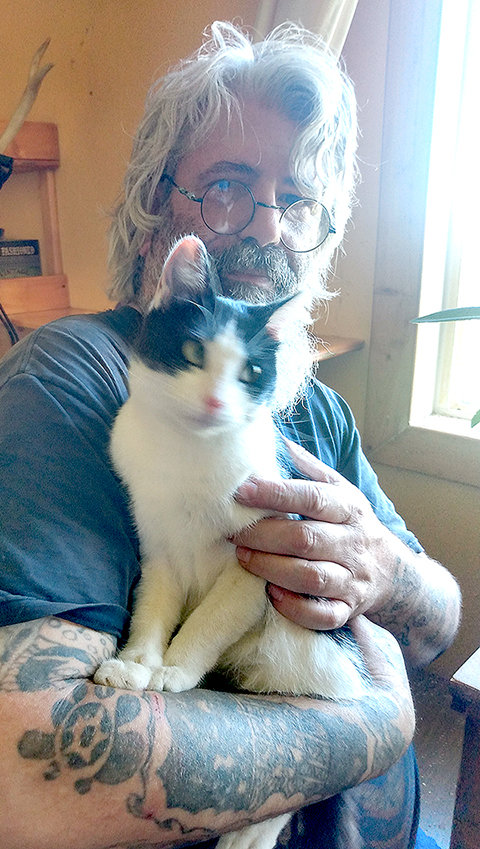 Mike Wicks poses with an abandoned cat he found on his rural Powell property last week. He says the illegal dumping of pets needs to stop.