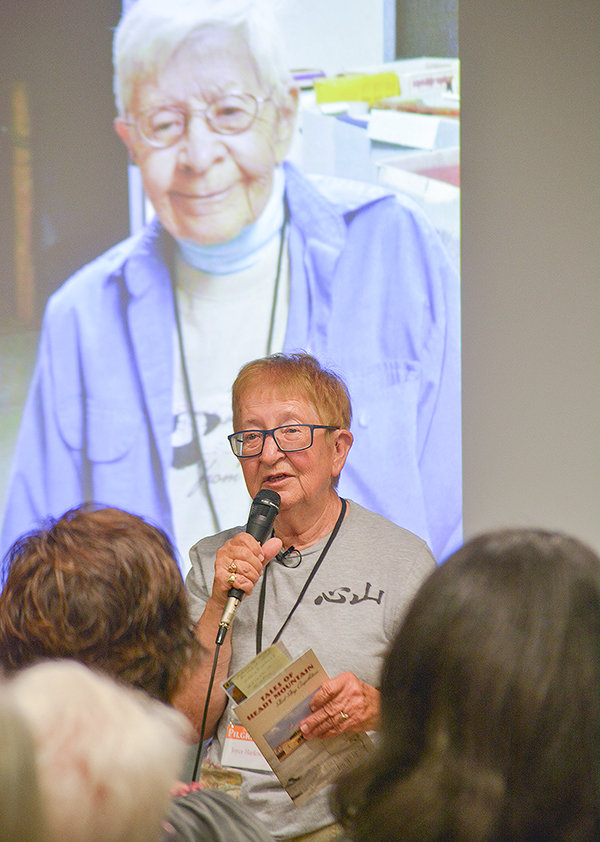 Joyce Harkness speaks about her partner, the late LaDonna Zall (shown smiling on the screen), during the annual Heart Mountain Pilgrimage on Saturday. Zall spent decades helping to tell the stories of the Japanese Americans who were incarcerated at the former relocation center between Powell and Cody.