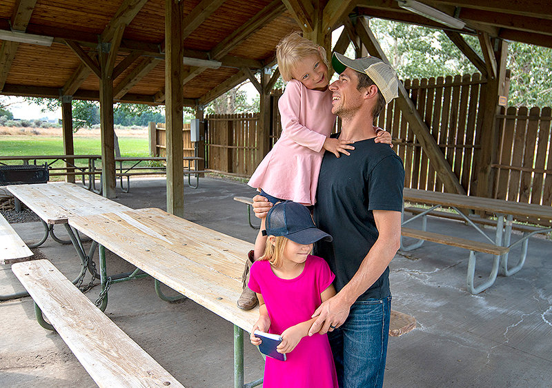 Jason Byer and his daughters Angelina, 6, and Anastasia, 4, hang out at a shelter at the Bartlett Day Use Area at Buffalo Bill State Park. It might be transformed into a temporary camping area for RVs to help the park keep up with record demand for camping facilities outside Yellowstone National Park.