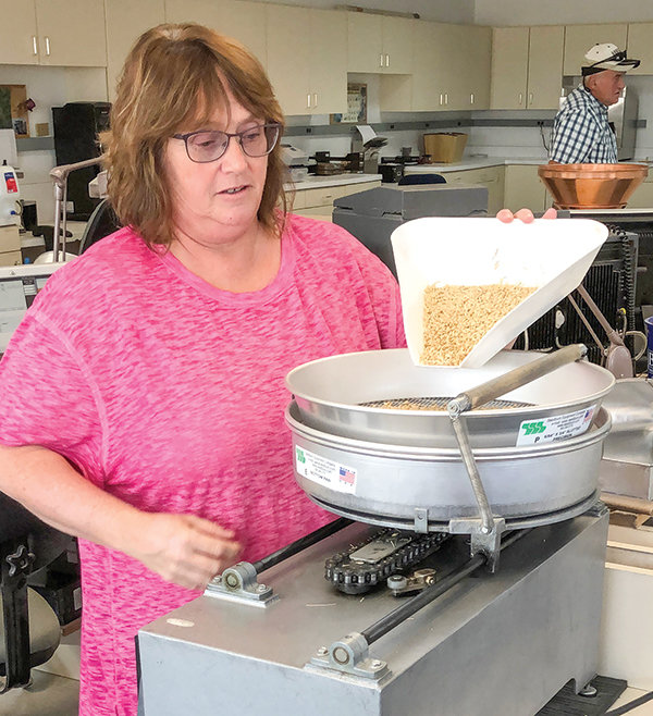 Judy Bullinger is office manager at Briess malt barley receiving station at Ralston. Responsible for quality control, she tests a sample from each delivery of barley.