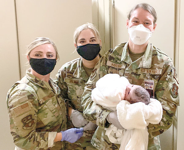 From left, Wyoming Air National Guard Administrative Specialist Senior Master Sgt. Jennifer Ballenger, Tech. Sgt. Shyloh Vallot and 2nd Lt. Kristin Harosia of the New York Air Guardsmen pose with a baby they helped deliver at McGuire-Dix-Lakehurst Air Force Base, New Jersey.