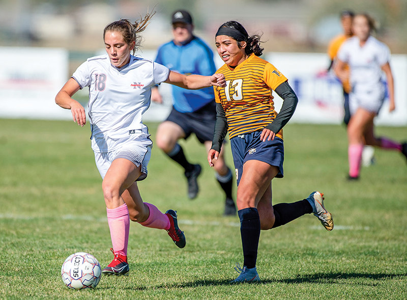Forward Peyton Roswadovski holds off a Western Nebraska defender during the first half of NWC’s match on Friday. Roswadovski would tally two goals and an assist during the match as the Trappers went on to win 3-0.
