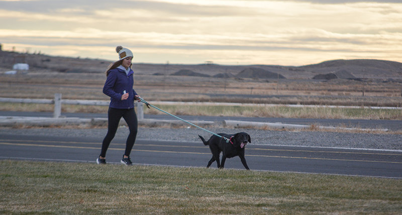 Anna Bartholomew and her pooch head down Seventh Street during Thursday’s ‘Run for the Robots’ Turkey Trot. The duo posted a time of 13:49 in the mile.