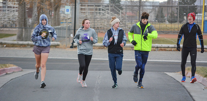 From left, Salem Brown, Kinley Cooley, Brynn Hillman and Ben Whitlock near the end of their 5K at Powell High School Thursday morning, as Ladell Merritt looks on. The quartet finished in 24:51.