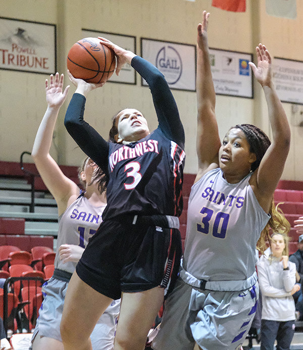 NWC sophomore Celina Tress shoots a layup over two Carroll College defenders during a matchup on Saturday. The Trappers led wire-to-wire in both victories over the Saints in their first home games of the season.