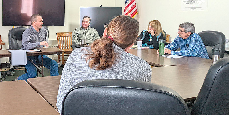 During a Tuesday meeting, Park County Commissioner Lloyd Thiel (at left) visits with fellow commissioners Lee Livingston, Dossie Overfield and Joe Tilden about ways the county could help protect homeowners; county planning director Joy Hill is seen in the foreground, with Commissioner Scott Mangold out of the frame.