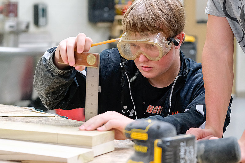 PHS freshman Colin Wilson checks his measurements during the high school Intro to Woods class.