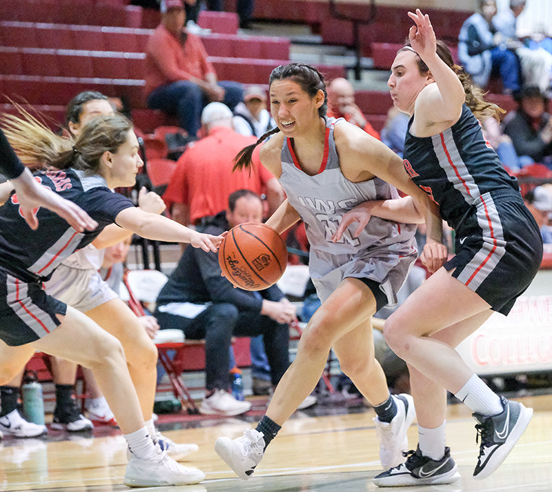 Needing a basket, freshman guard Nayeli Acosta drives in between two Casper College defenders during the second half of their matchup on Saturday. Acosta and the Trappers comeback attempt in the fourth quarter fell just short as they dropped the home contest to the TBirds 75-68.