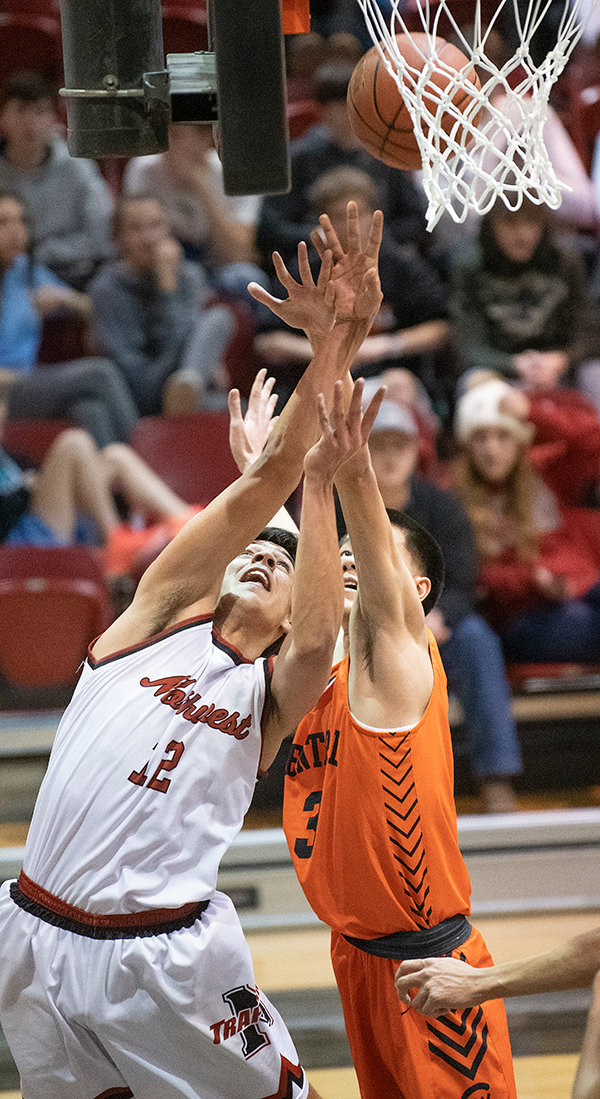 Trapper sophomore Gabriel Gutierrez battles Central Wyoming’s Steven Long under the basket to put up two points Monday night at the Cabre Gym. Coming back from an eight-point deficit, the Trappers were able to secure a 70-68 win in the final seconds of the game.