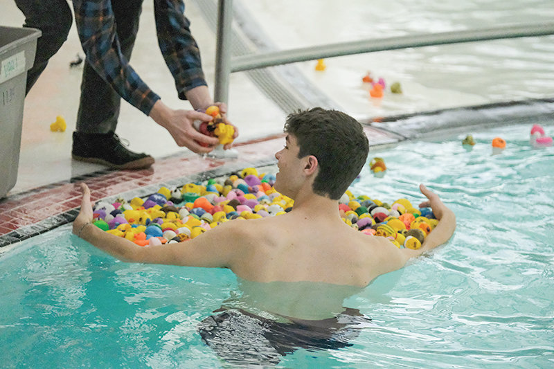 PHS senior Ethan Bartholomew rounds up ducks for collection after the race at the Powell Aquatic Center.