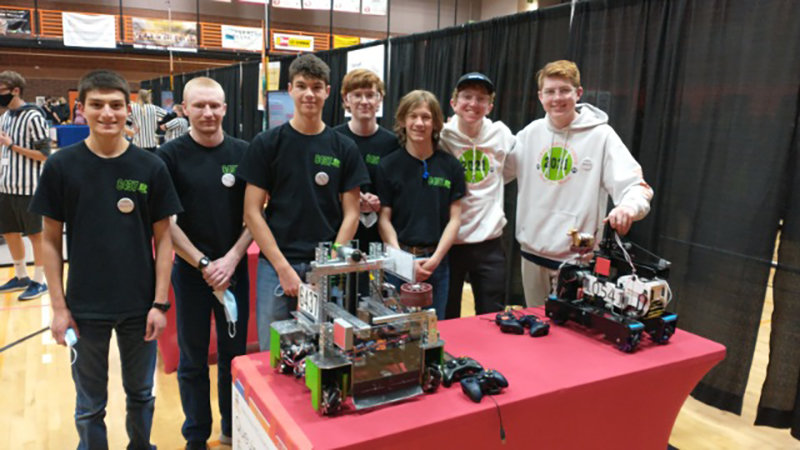 From left, Phillip Ellis, Francis Rogers, Ethan Bartholomew, Gus Miller, Gabe Rose, Kalin Hicswa and Wesley Hoffman pose with their robots.