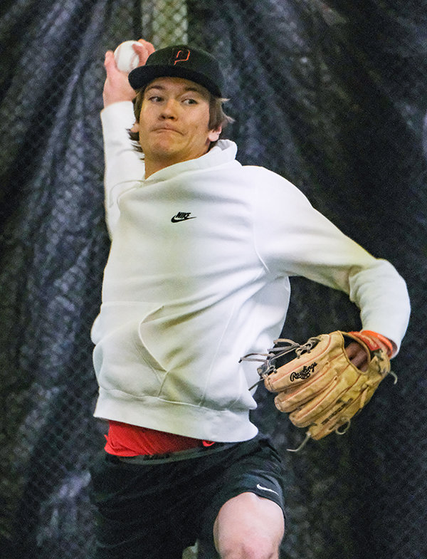 Trey Stenerson winds up to pitch as the Pioneers gear up for their season during a Tuesday practice indoors. The baseball teams open the season on Saturday against Miles City.
