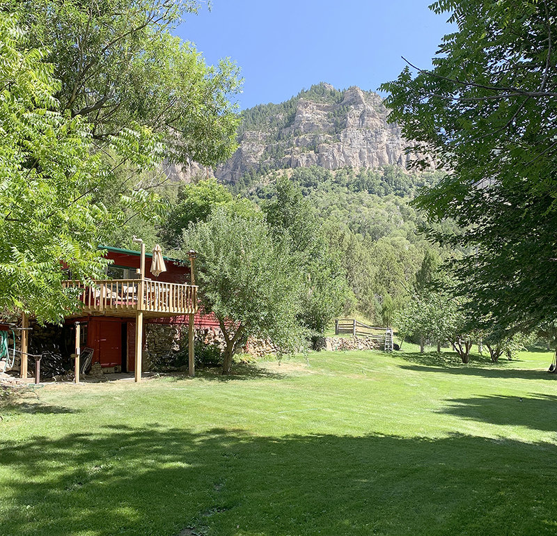 The house which was built using the terrain in the Wind River Canyon peeks out from behind trees in the Wind River Canyon.