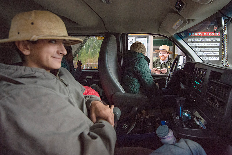 Tommy Catone, in his pith helmet, finally gets his wish to enter Yellowstone National Park through the East Entrance while his mother, Jenny Catone, purchases a pass into the park from lead recreation fee technician Jeff Moynihan. The family, including Lily and Sophia, had waited 11 1/2 hours to enter the park for the season opener at 8 a.m. Friday.
