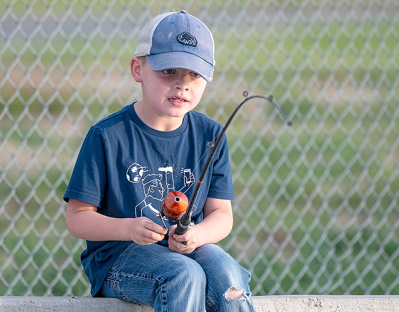 Logan Hill watches his line while participating in the 2021 Kids Fishing Day at Homesteader Park.