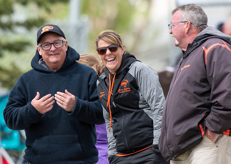 Panthers track coaches Scott Smith, Ashley Hildebrand and Nevin Jacobs joke around as they wait to hear the results of the team scores from the state track meet.