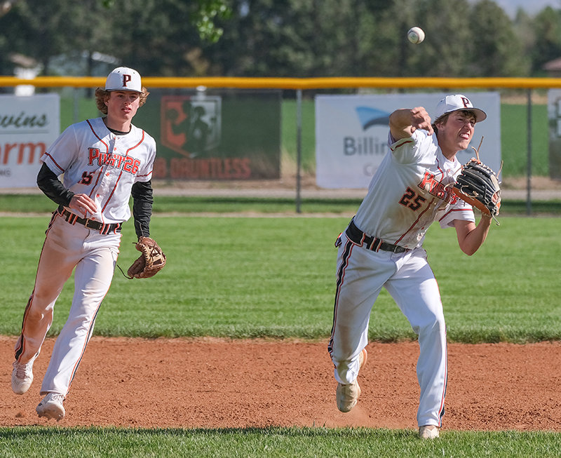 Cade Queen (right) follows through on his throw as teammate Brock Johnson (left) watches. The Pioneers escaped with two narrow victories 8-7 and 7-6 over Sheridan on Tuesday night.