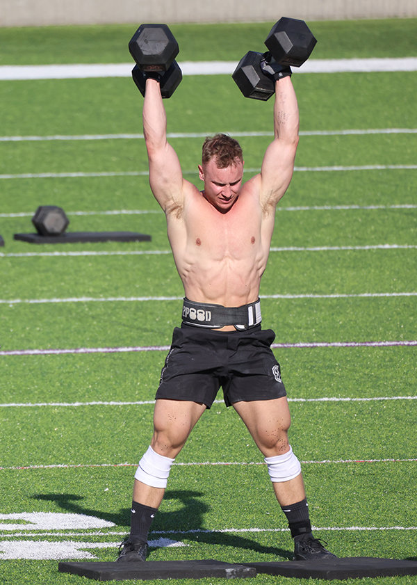 Cooper Wise lifts dumbbells up over his head while competing at the Granite Games last summer. Wise qualified for his second straight NOBULL CrossFit Games this year in August.