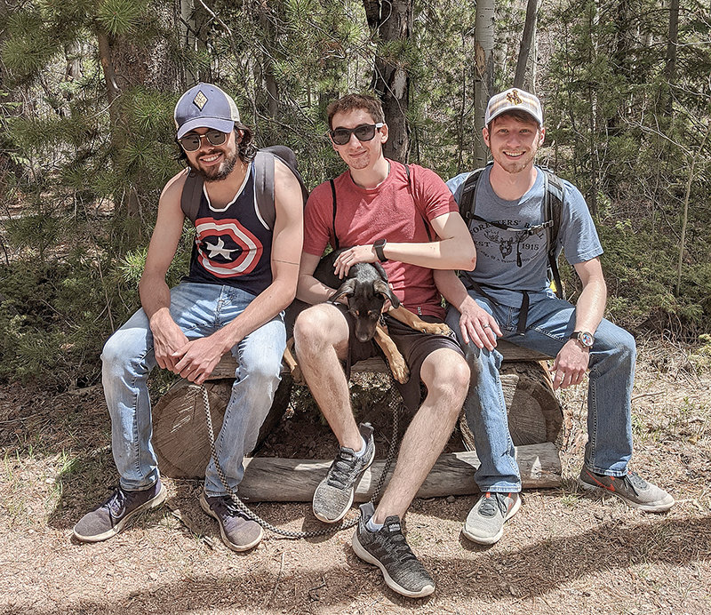 Braden Schiller (left), Christian Bitzas and Wade Musso take a break from hiking at Happy Jack in Albany County while Bitzas holds a restless Rocco.