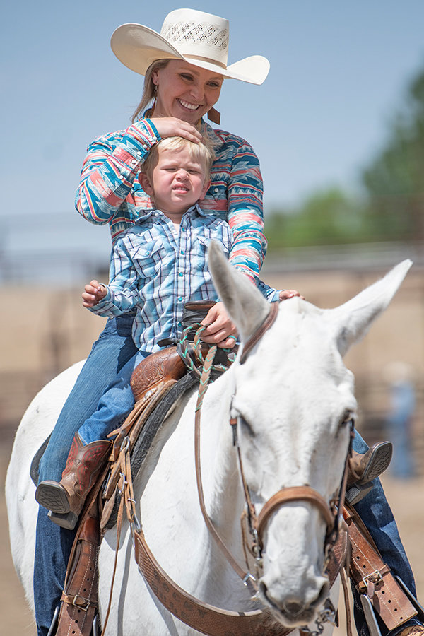 Sidney Wells of Payette, Idaho, helps young Weston Wells run the barrels.