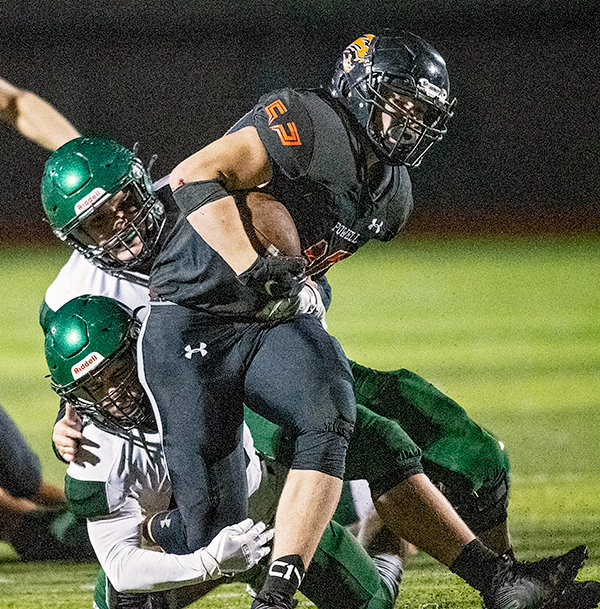 Toran Graham drags Green River defenders as he carries the ball during a game in October. Graham was recently named to the NFF’s Team of Distinction.