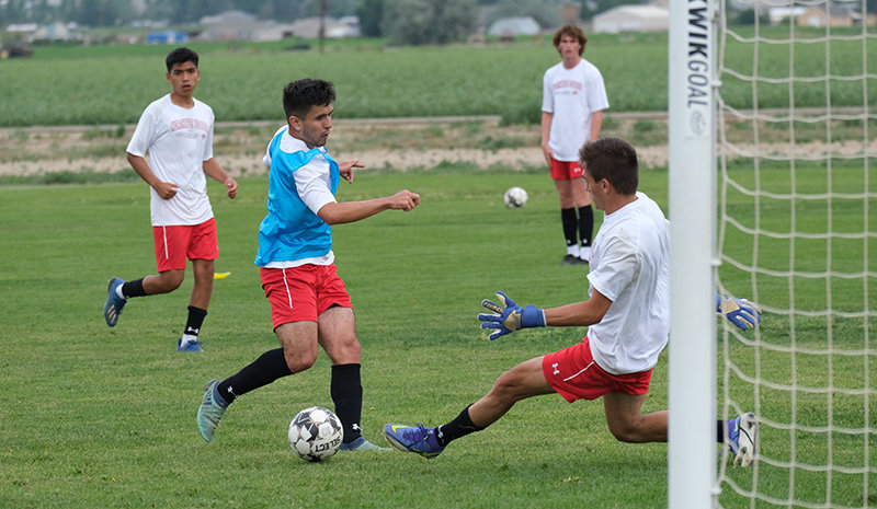 Martin Weisner slides a shot past Inigo Chavarria Bezunartea during practice last week as a new-looking Trapper men’s soccer team prepped for its first action this week. The team begins play Wednesday in Billings.