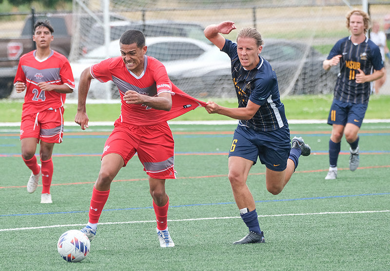 NWC freshman Ricardo Farias da Silva (center) tries to get away from a Montana State University Billings defender during the Trappers exhibition game on Saturday.