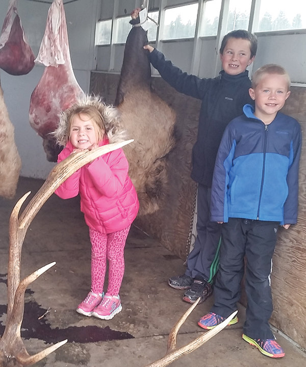 Charlee, Curtis and Tucker Muecke help harvest an elk taken by their father. Wild game is an important part of the family’s diet.