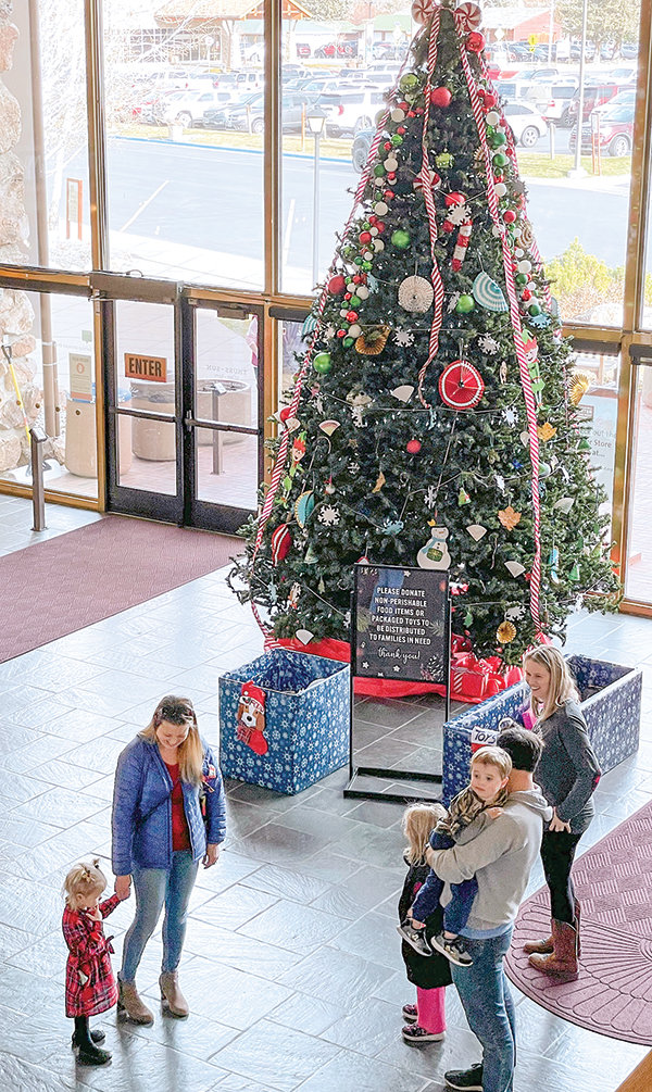 Visitors to the Buffalo Bill Center of the West’s 2021 Holiday Open House chat and enjoy the Christmas decorations.