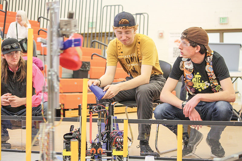 PHS seniors Kalin Hicswa and Daniel Merritt prepare to drive their robot in the upcoming cup stacking challenge.