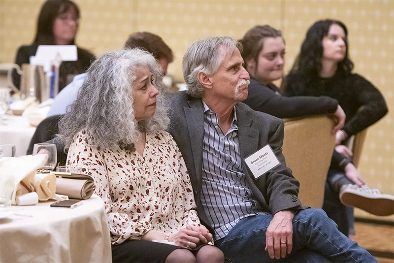 Bruce and Cecilia Moats listen to a ceremony honoring the late Jim Angell, a former Wyoming Press Association executive director, during the association's January 2023 convention.