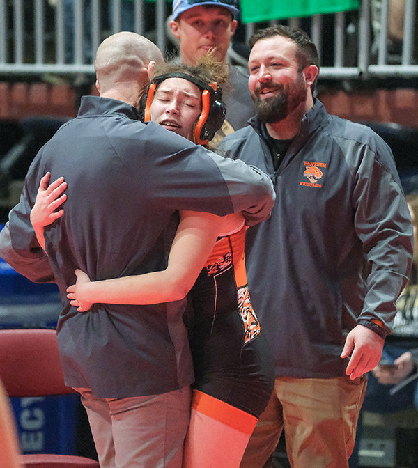 Yessenia Teague embraces coaches Juston Carter and Cody Kalberer after finishing the last match of her high school career on Friday in Casper.