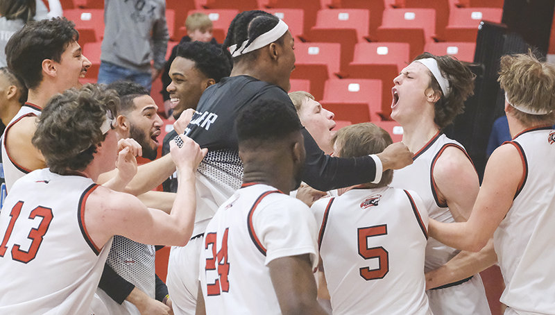 The Trappers swarm Kolter Merritt after he tipped in the game winning shot against Lamar Community College on March 9.