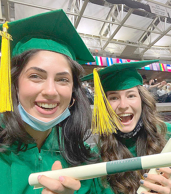 Powell graduate and STARR scholar Maddy Hanks (right) holds her diploma alongside her freshman year roommate Isabella Racette.