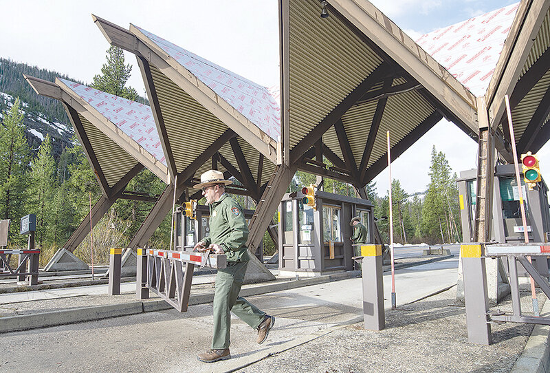 East Entrance Fee Supervisor Chris Baltz swings open the gate, opening the entrance for business for the 2023 season. Baltz is in his first year at Yellowstone National Park.