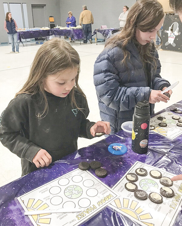 Using Oreos, Powell Christian School students Kendal Kolacny and Leila Brown learn about moon phases.
