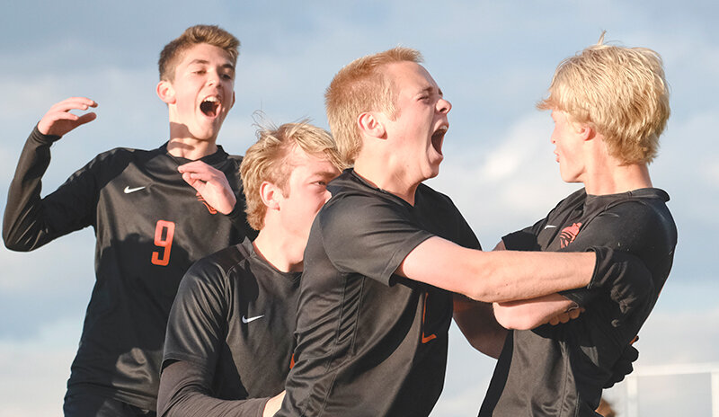 Chance Franks (right) is swarmed by Bryce Haslem (from left), Landon Hernandez and Jacob Orr after he scored a free kick on Friday against Green River. The Panthers won their first ever 3A West Conference title at Panther Stadium after earning a point against the Wolves.