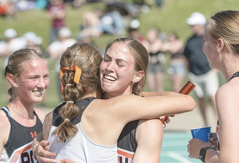 Megan Jacobsen embraces Anna Bartholomew and is surrounded by her sister Kenna Jacobsen (left) and Audrey Johnson (right) after the 4x400 relay earned enough points to capture the team’s third straight title on Saturday.