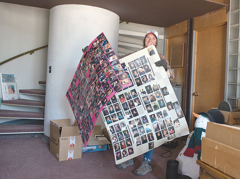 Erin Johnson shows two large sheets of senior portraits from 1993 discovered in the First National Bank Building after her daughter, Alleigh Richardson, purchased the building last year.