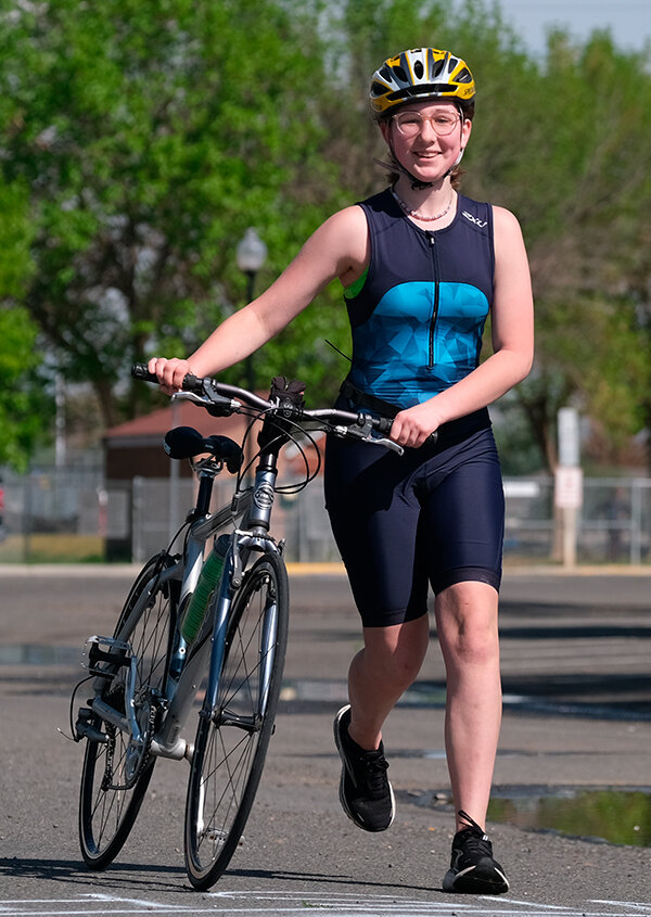 Emma Thompson smiles after hopping off the bike while competing in her first triathlon.